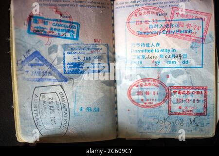 Immigration stamps in well-used US passport from China, Thailand and Australia Stock Photo