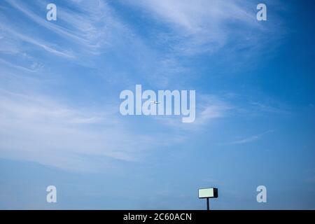 a blue sky and a small plane that can be seen far away. Stock Photo