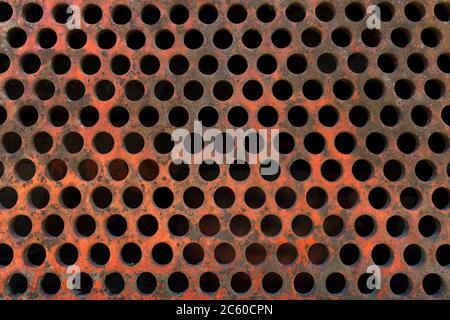 Very old, rusty, reddish perforated plate Stock Photo