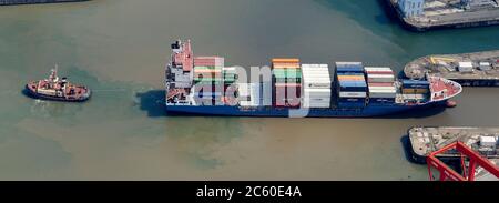 An aerial view of a container ship leaving Seaforth Docks, Liverpool, Merseyside, North West England, UK