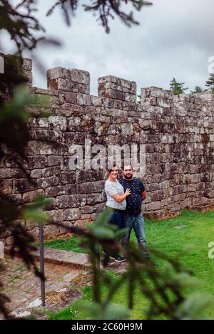 Couple with the inner wall of the Soutomaior medieval castle in Galicia, Spain Stock Photo