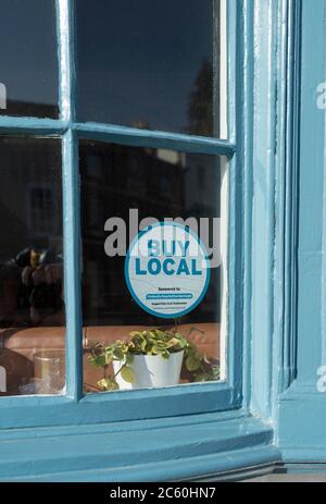 Sticker in a window encouraging people to buy from local shops in the UK. Stock Photo