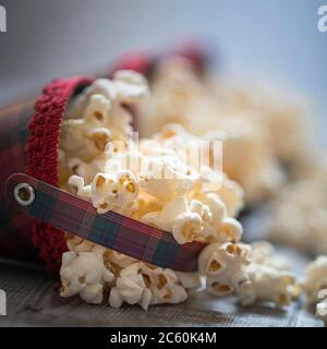 Popcorn in retro plaid cones, over old wood background. Stock Photo