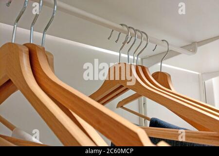 Wooden hangers hanging in an empty closet Stock Photo