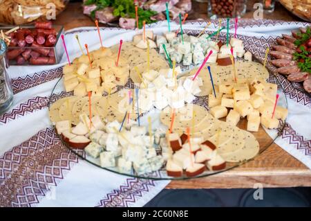 Wedding buffet. Slicing different varieties of cheese Stock Photo