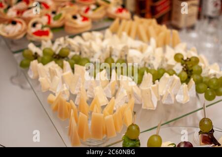 Wedding buffet. Slicing different varieties of cheese Stock Photo