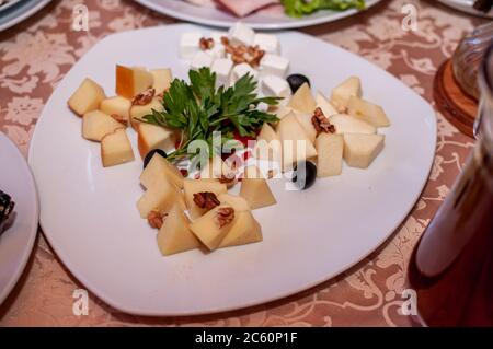 Wedding buffet. Slicing different varieties of cheese Stock Photo