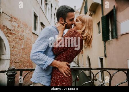 Beatiful young couple having fun while visiting Venice - Tourists travelling in Italy and sightseeing the most relevant landmarks of Venezia - Concept Stock Photo