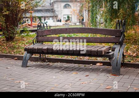 Wooden bench with a metal railing in the park Stock Photo