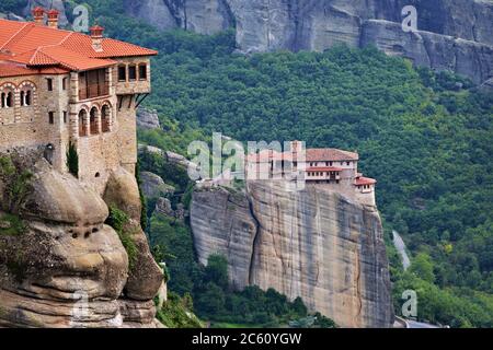 Meteora monasteries. Beautiful evening view on the Holy Monastery of Varlaam placed on the edge of high rock,  Roussanou Monastery on background. Kast Stock Photo