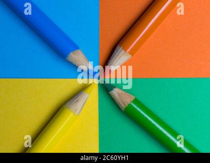 Colored pencil crayons arranged on matching colored card surface Stock Photo