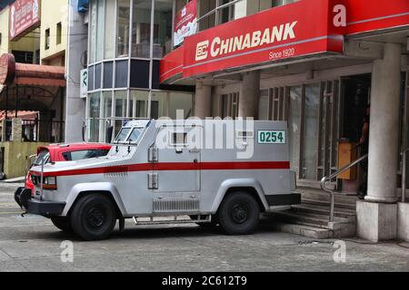 MANILA, PHILIPPINES - DECEMBER 8, 2017: Armored truck team handles money at Chinabank in Manila, Philippines. Chinabank groupa has 450 branches in Phi Stock Photo