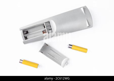 TV remote control and yellow batteries isolated on white background. Battery change/replacement parts Stock Photo