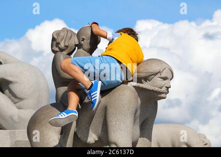 OSLO, NORWAY - AUGUST 2, 2015: Unidentified child plays at Vigeland Installation in Frogner Park, Oslo. 212 sculptures around the park were all design Stock Photo