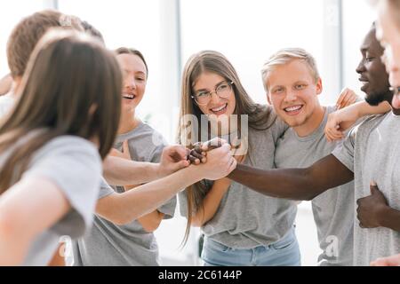 two guys shaking hands standing in a circle of friends Stock Photo