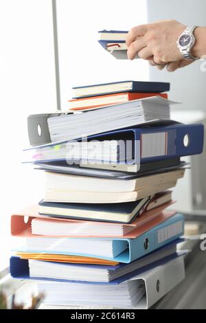 Male hands working in stacks of paper files Stock Photo