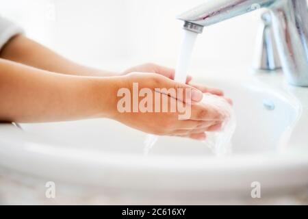 Child is washing hands under running water. Stock Photo