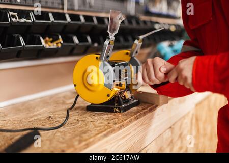 Close up foreman using yellow knife sharpener in workshop isolat Stock Photo