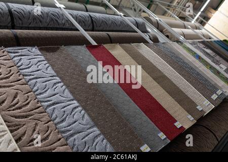 samples of carpets of different colors hung in a textile store Stock Photo