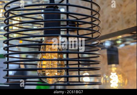 Light bulb in vintage style with black metal lampshade. Edison lamp in the loft interior. Stock Photo