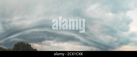thundercloud rolls across the sky at sunset Stock Photo