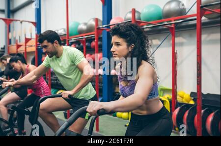 Athletes doing air bike indoor Stock Photo