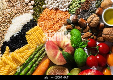 basic vegan ingredients and products. cereals, legumes, fresh vegetables and fruits, oils, seeds and nuts. balanced healthy diet isolated on white Stock Photo