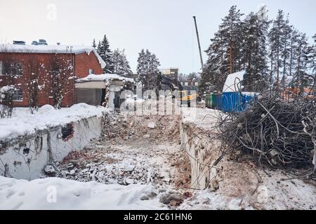 Bulldozer demolished old building in winter. Stock Photo
