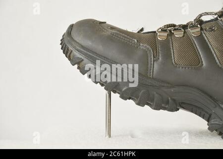 Worker in safety boots, leather stepping on a nail, leather boot in side view, white background, blurred background, zoom, Brazil South America Stock Photo
