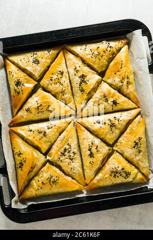 baked in the oven indian samosa made with phyllo with spicy potatoes and vegetables with black sesame seeds. street traditional fast food Stock Photo