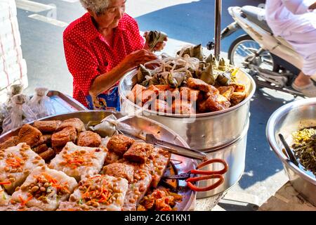 Old woman selling street food in Yaowarat Road, Bangkok, Thailand Stock Photo