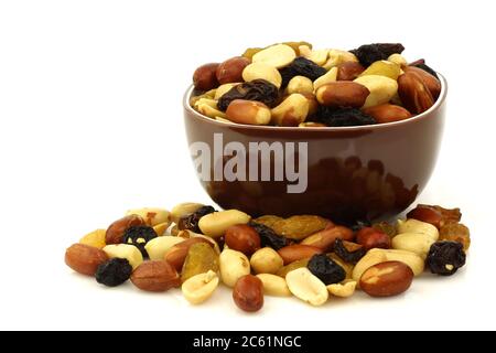 mixed peanuts and raisins in a brown bowl on a white background Stock Photo