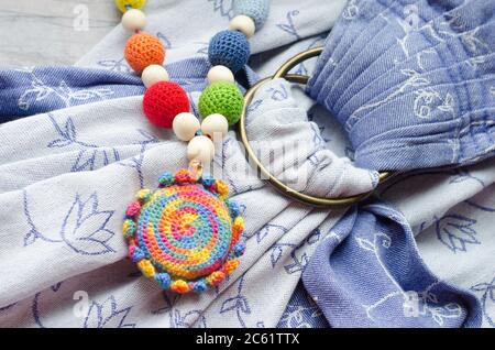 Necklace made from knitted beads and toys for the baby sitting in a sling. Knitted beads. Sling necklace. Stock Photo