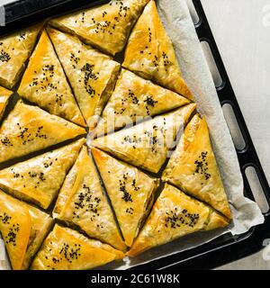 baked in the oven indian samosa made with phyllo with spicy potatoes and vegetables with black sesame seeds. street traditional fast food Stock Photo