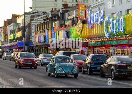 Amusement arcades illuminated along Marine Parade, Southend on Sea, Essex, UK. Classic Volkswagen Beetle car driving passed Monte Carlo arcade Stock Photo