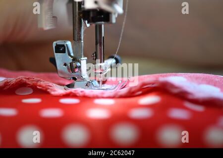 Sewing machine foot on material with threaded needle ready to sew Stock Photo