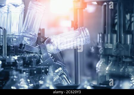 Plastic PET recycled bottles preparing for filling with drink. Water and juice bottling factory in blue color. Stock Photo