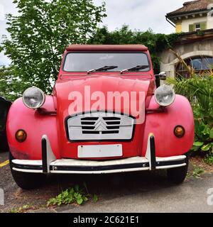 Vitznau, Switzerland - June 14, 2017: Red Vintage Citroen 2CV6 retro car named Duck on parking place at the city street. Stock Photo
