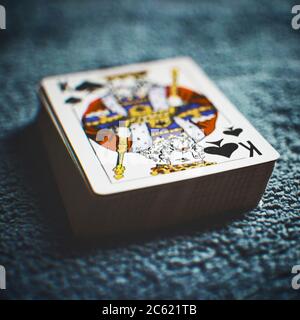 Deck of new cards on a dark blue table, peak king first. Stock Photo