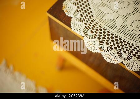 crocheted white doily on the bedside table Stock Photo
