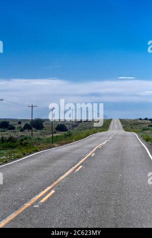 A long straight empty road stretching into the distance Two white ...