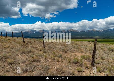 Old barbed wire fence with rocky mountains, Colorado, USA Stock Photo