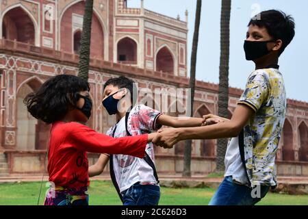 Kids wearing face mask as a preventive measure play in front of Humayun's Tomb.Humayun's Tomb (monument), reopened its doors for visitors after a three-month of lockdown that was imposed to slow the spread of the coronavirus disease (COVID-19), in New Delhi. New Delhi (capital of India) has crossed 1 lakh mark cases of covid19, Total number of cases 1, 00,823 with 1379 new cases reported in the last 24 hours, and Total death 3,115 from the coronavirus Stock Photo
