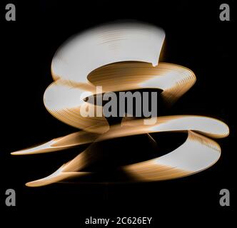 A swirl of blue light painted in a corkscrew at night in this long exposure abstract photograph Stock Photo