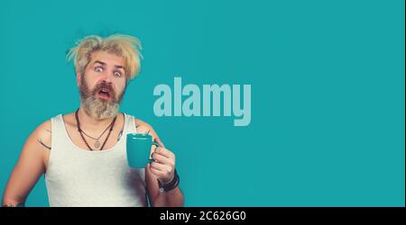 Tired drunk man after party at home with cup coffee. Stock Photo