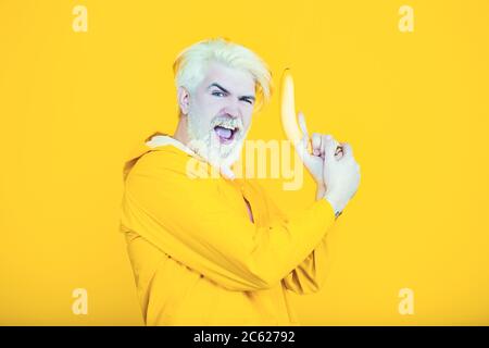 Funny bearded man holds a pistol in his hand and poses for the camera. Stock Photo