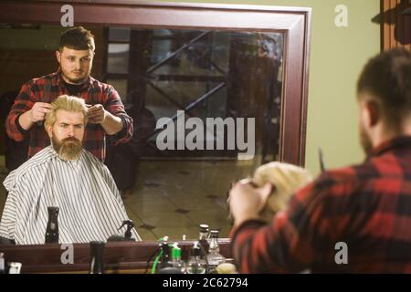 Side view of serious man with stylish modern haircut looking forward in barbershop. Stock Photo