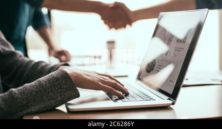 close up. employee using a laptop at the workplace in the office. Stock Photo
