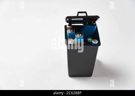 Used batteries in black garbage container on white background. Recycling batteries concept. Stock Photo