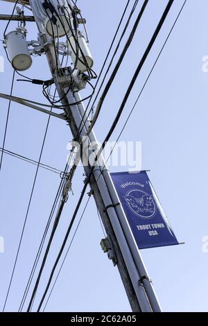 Typical US style power cables seen atop a newly installed pole showing transformers and other signage attached to the pole itself. Stock Photo
